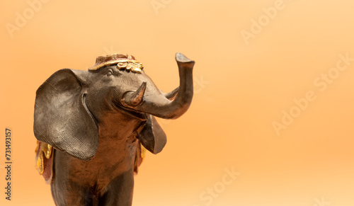 Mockup World Elephant Day. Bronze Decorated Elephant On Peach Yellow Background. Copy Space For Text. Ganesha Chaturthi Holiday. Sacred Symbol In Hindu And Buddhist Religions. Design, Horizontal Plane