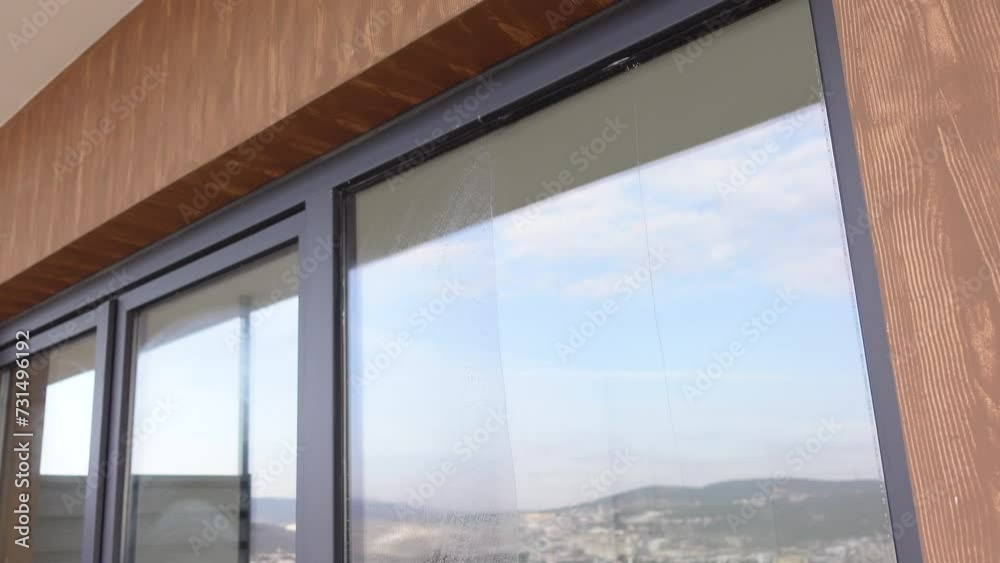 Rubber squeegee cleans a soaped window. Rubber squeegee cleans a soaped window.