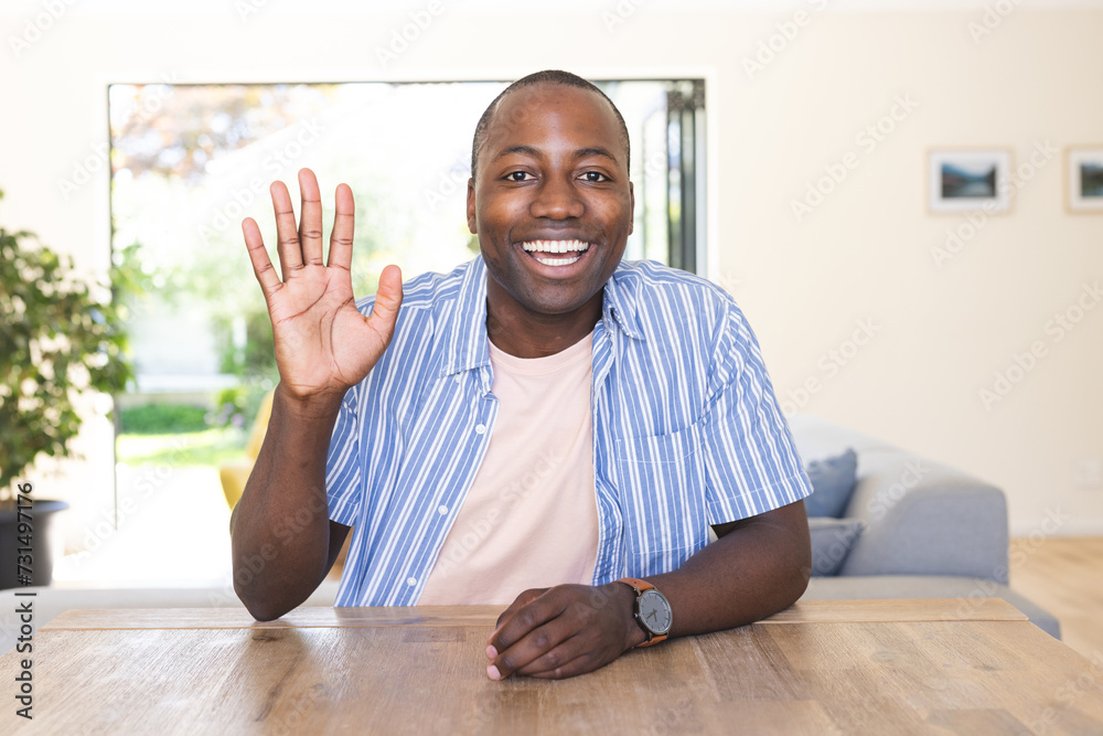 Young African American man waves cheerfully at home on a video call Young African American man waves cheerfully at home on a video call