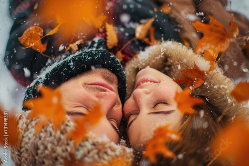 Happy couple rolling in late autumn snow with orange leaves © Kien