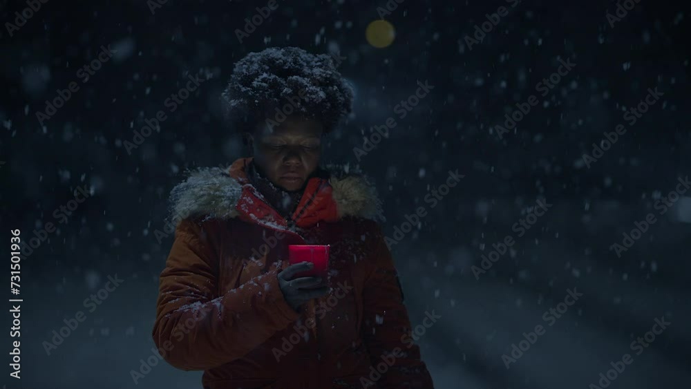 Young African Woman Standing on Street at Night During Snow Fall with Umbrella Young African Woman Standing on Street at Night During Snow Fall with Umbrella