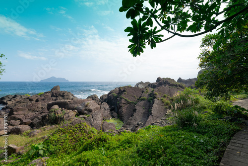 Trail by the coastline hidden in the woods and Guishan Island from the distance at Yilan, Taiwan.