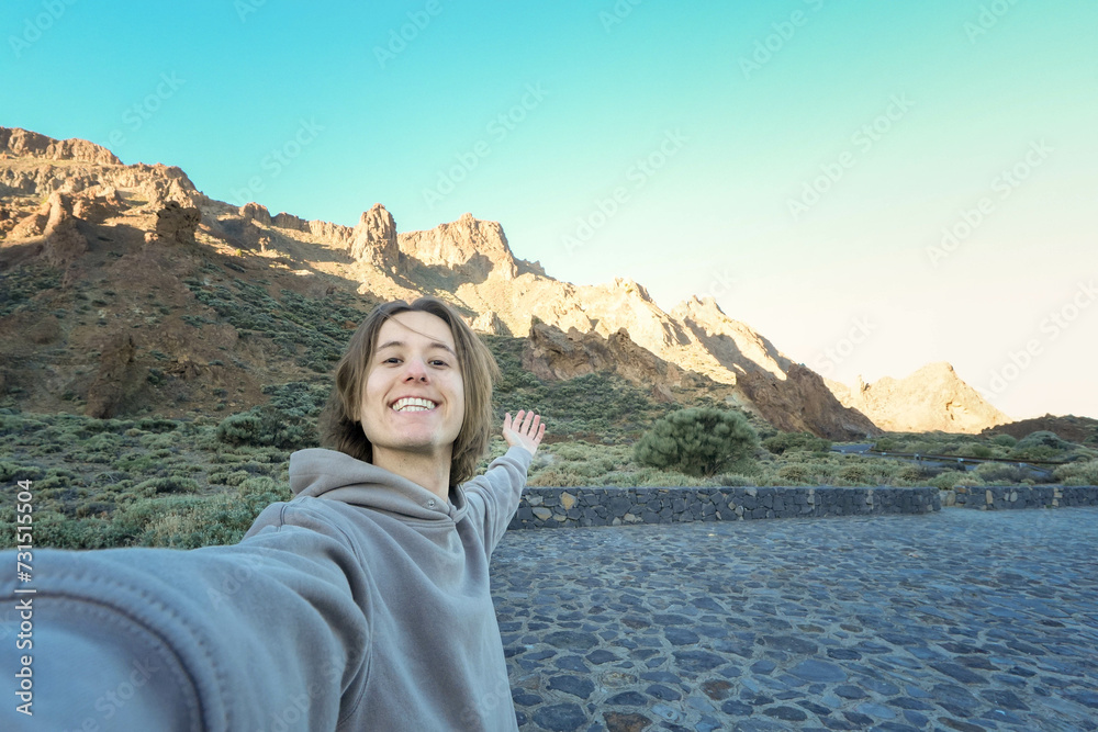 Smiling young man Taking a Selfie in a Mountainous Landscape at Dusk