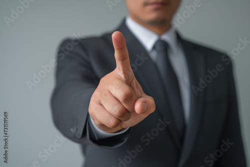 Businessman in suit pointing with hand, conveying success and agreement gesture