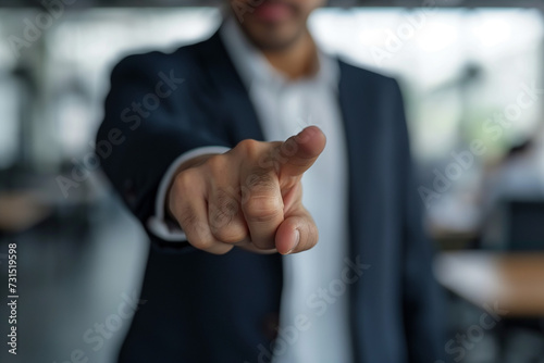 Businessman in suit pointing with hand, conveying success and agreement gesture