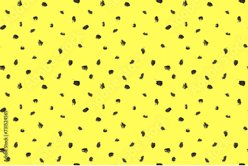 Dash pattern on yellow background. Wrapping paper with small black dots painted with a brush. Seamless simple minimal ornament. Abstract geometric grunge vector texture painted by ink.