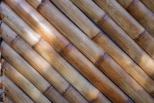 a fence made from an arrangement of bamboo sticks that have been varnished.