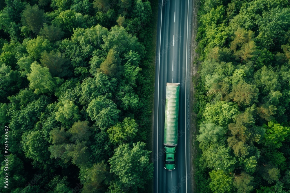 Top view of a gasoline truck driving on a highway amidst a green forest Top view of a gasoline truck driving on a highway amidst a green forest