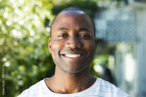 Young African American man smiles brightly outdoors photo