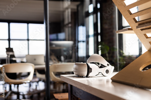 A VR headset rests on a table in a modern casual business office photo