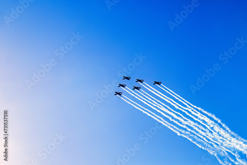 Fighter planes in formation flight with white condensation trails