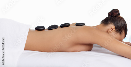 Health, hot stone and woman with massage at spa for wellness, natural and back treatment. Self care, cosmetic and calm young female person sleeping for warm rock skin therapy at beauty salon.