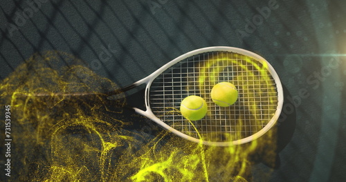 Image of glowing yellow particles over tennis balls on racket