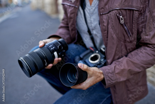 Camera lens, outdoor and hands of photographer to work in city on photoshoot with professional gear to film on street. Shooting, photography and cameraman closeup with tech to capture media in town © Miko/peopleimages.com