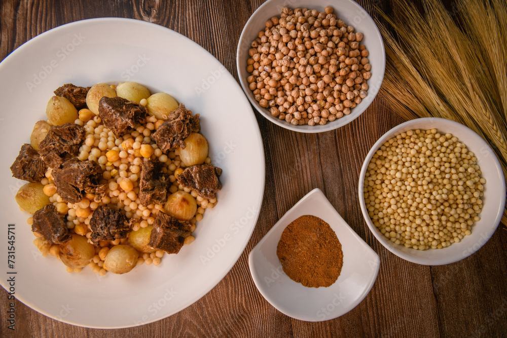 Moughrabieh is a popular dish in the Lebanese cuisine, LEBANESE RECIPE FOR MOUGHRABIEH WITH BEEF AND SMALL ONIONS, SEMOLINA PEARLS AND CHICKPEAS. High quality photo Moughrabieh is a popular dish in the Lebanese cuisine, LEBANESE RECIPE FOR MOUGHRABIEH WITH BEEF AND SMALL ONIONS, SEMOLINA PEARLS AND CHICKPEAS. High quality photo