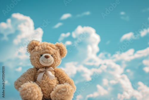 Toy bear sitting against cloud and sky background