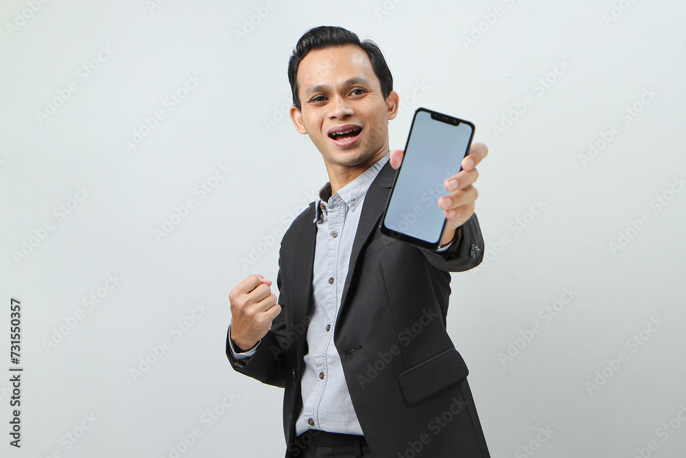 Happy confident asian indonesian business man in suit showing blank smartphone screen on isolated background Happy confident asian indonesian business man in suit showing blank smartphone screen on isolated background