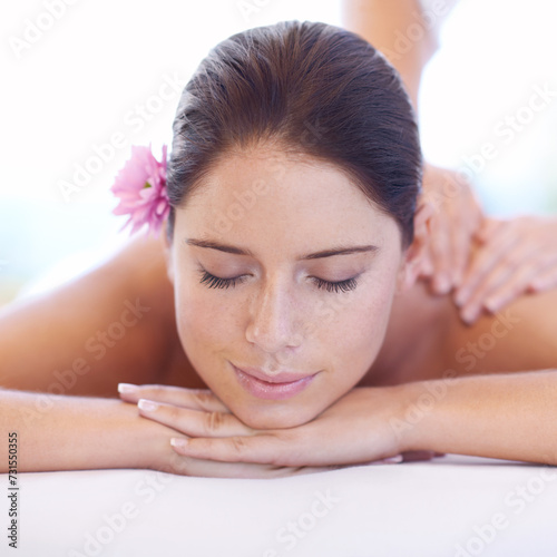 Relax, massage and face of woman at spa with smile, flower for health with luxury holistic treatment. Self care, peace and girl on table with masseuse for body therapy, wellness and hotel service