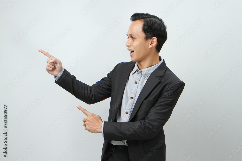 Happy confident asian indonesian business man in suit with pointing finger gesture on isolated background Happy confident asian indonesian business man in suit with pointing finger gesture on isolated background
