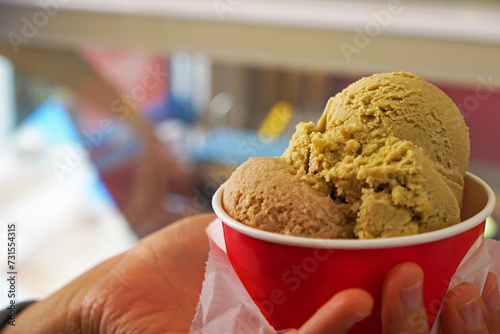 Close up Hand holding red paper take away cup of ice cream gelato photo