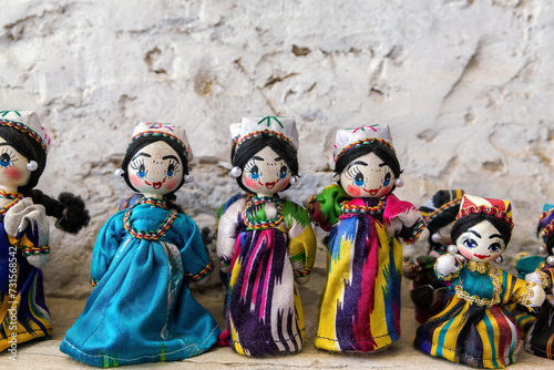 Dolls dressed in traditional uzbek costumes. Traditional souvenir puppet from painted mashed paper (papier mache). Close up, selected focus. Bukhara (Buxoro), Uzbekistan. Souvenir and gift concept