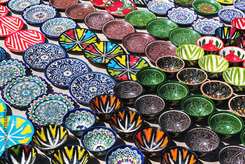 Traditional ceramics, typical handicraft uzbek souvenir. Multicolored pots and plates in Bukhara street market. Uzbekistan