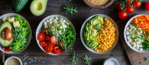 Healthy diet bowls filled with a variety of vegetables, including avocado, cheese, tomatoes, and groats.