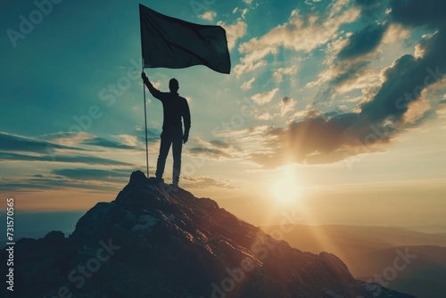 Businessman holding flag on mountain, representing success and leadership.