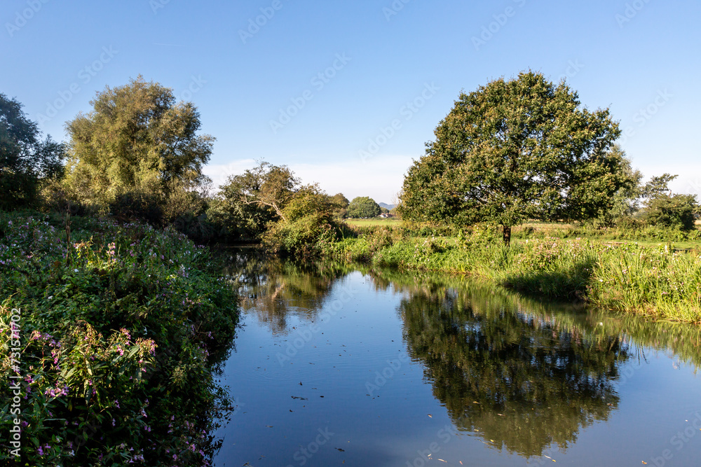 Fototapeta premium A view of the River Ouse at Barcombe Mills, with a blue sky overhead
