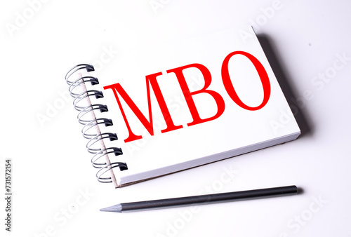 Text MBO on notebook on the white background, business