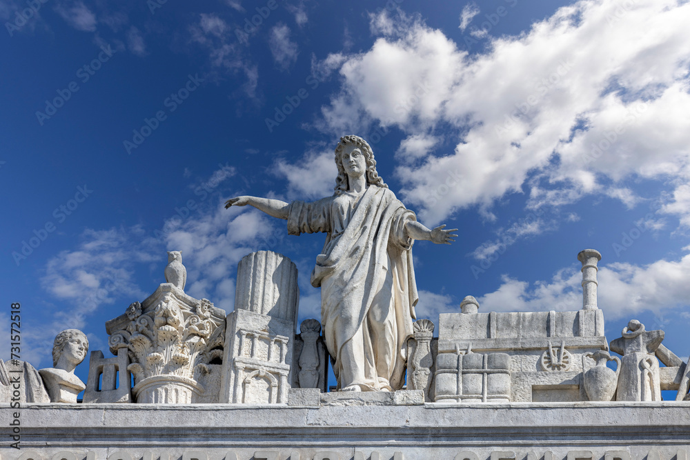 Obraz premium Sculptures on top of the 19th century Stratto Palace located on Unity of Italy Square, Trieste, Italy