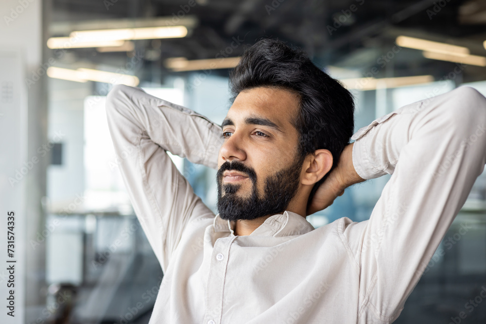 Relaxed businessman in office with raised eyebrow and beard. Relaxed businessman in office with raised eyebrow and beard.