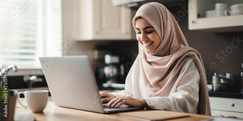 Smiling woman in hijab using laptop, home office setting. Workplace diversity. Generative AI
