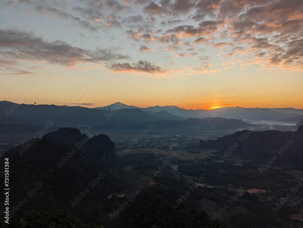 Person enjoys Sunrise at View Point in Vang Vieng, Laos at Pha Ngern View Point. Sunning view early morning, view until Nam Ngum