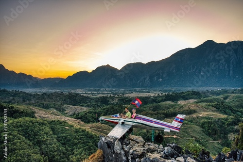 Sunrise in Vang Vieng at Phapoungkham viewpoint. Airplane on the top of the mountain, Sunset time, sun goes down, amazing view photo