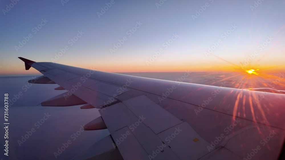Background of an airplane wing flying in the sky at sunset. Orange sky and copy space. Backlit on sunset time against the sun. Background of an airplane wing flying in the sky at sunset. Orange sky and copy space. Backlit on sunset time against the sun.