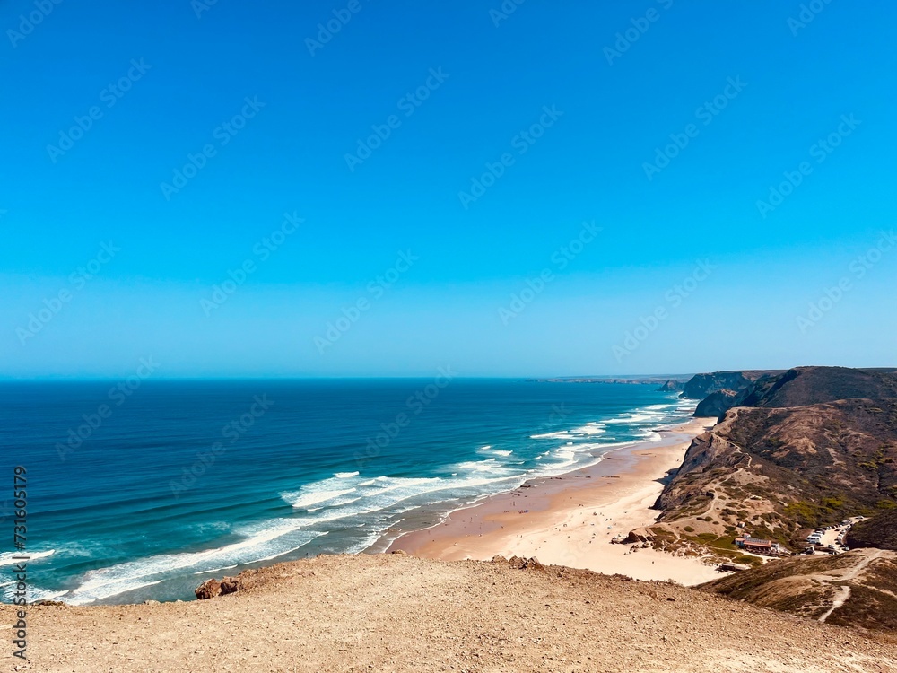 Rocky coast of the ocean bay, clear blue sky, ocean horizon, rocks