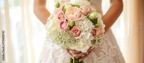 The bride holds a luxurious white wedding bouquet in pastel shades with roses, carnations, and hydrangeas. photo