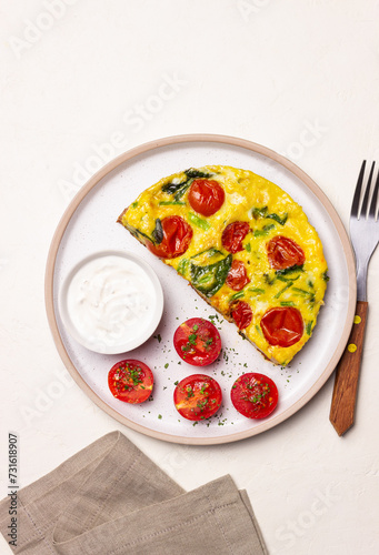 Frittata with tomatoes and spinach. Italian cuisine. Vegetarian food.