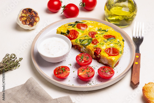 Frittata with tomatoes and spinach. Italian cuisine. Vegetarian food.