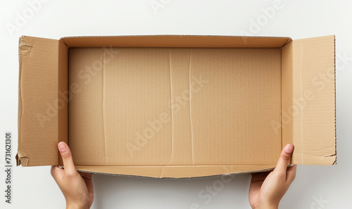 hands hold an opened box cardboard on white background top view. © Luciana Studio
