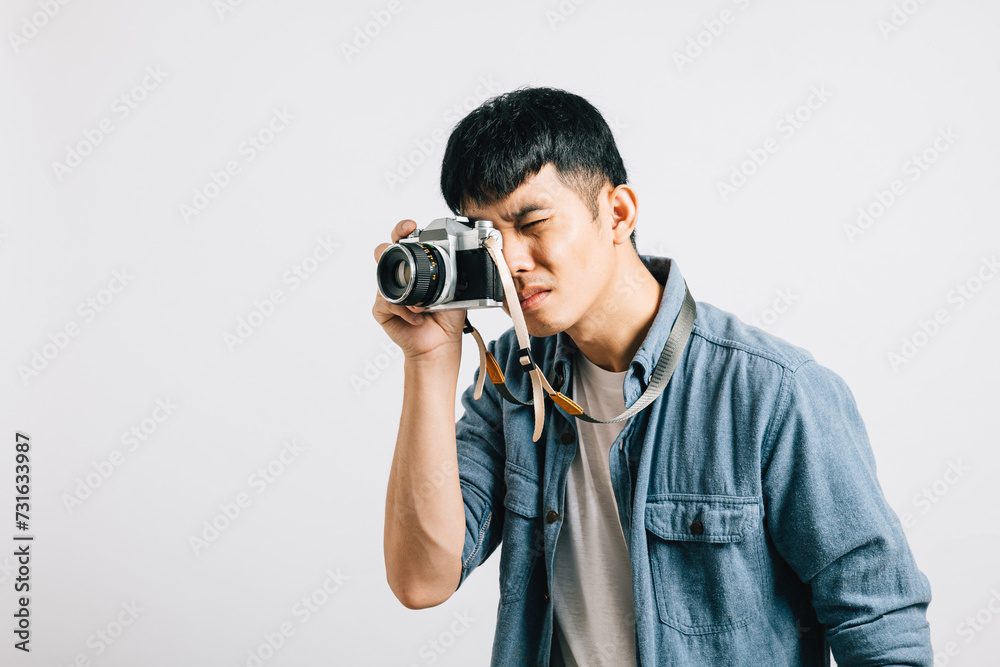 A charismatic young man enjoys a fun photography session with a vintage camera. Studio shot isolated on white background. His captivating look is pure paparazzi style A charismatic young man enjoys a fun photography session with a vintage camera. Studio shot isolated on white background. His captivating look is pure paparazzi style