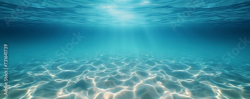 Stunning underwater view of the ocean with sun rays dancing across the sandy ocean floor
