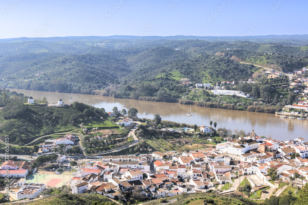 Aerial view of Sanlucar de Guadiana village in Huelva province, Andalusia with old white windmills in a hill, on the banks of Guadiana river, in the border of spain with portugal