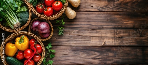 Top view of wooden table with wicker baskets filled with fresh garden vegetables, organic harvest.