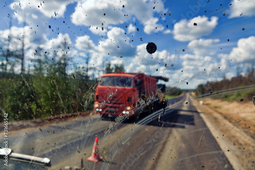 Dirty road after rain. Dirt highway with dirt flies on the windshield from other cars, dirty conditions for driver. Road repair continues