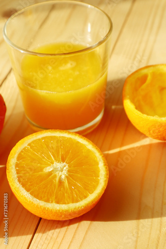  Fresh ripe  oranges  and glass of juice on wooden background   