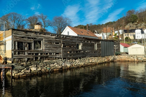 Antique wooden structure situated close to a tranquil riverbank photo