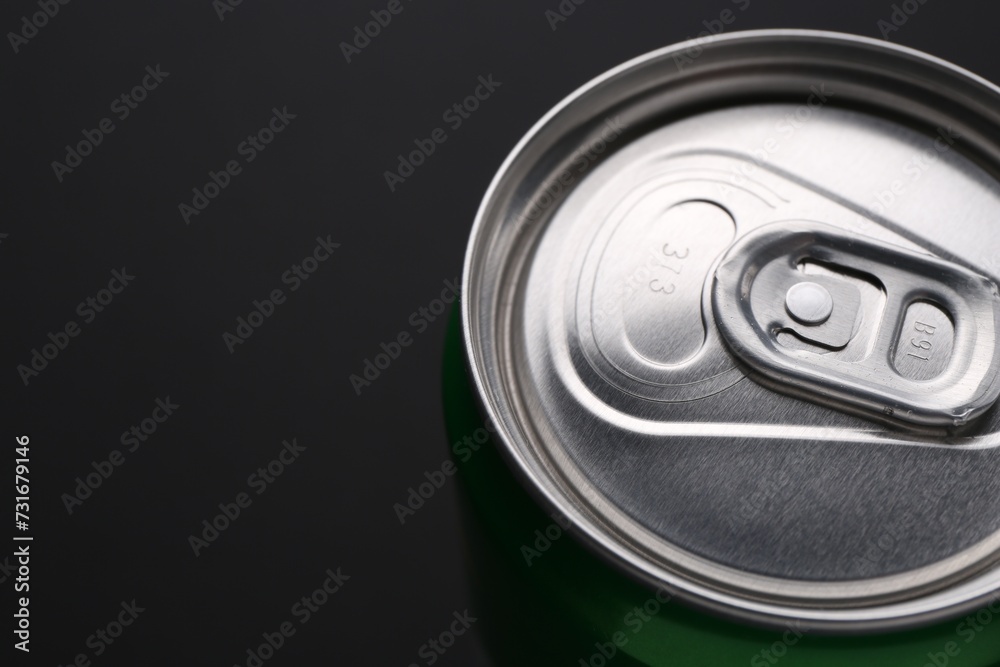 Energy drink in can on black background, closeup. Space for text