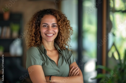 Woman smiles arms crossed in the office displaying confidence and positivity, people laughing picture